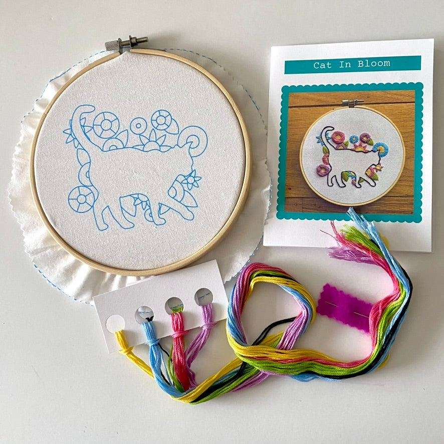 Cat In Bloom Embroidery Kit with hoop, preprinted fabric, needle, thread, and stitch guide.