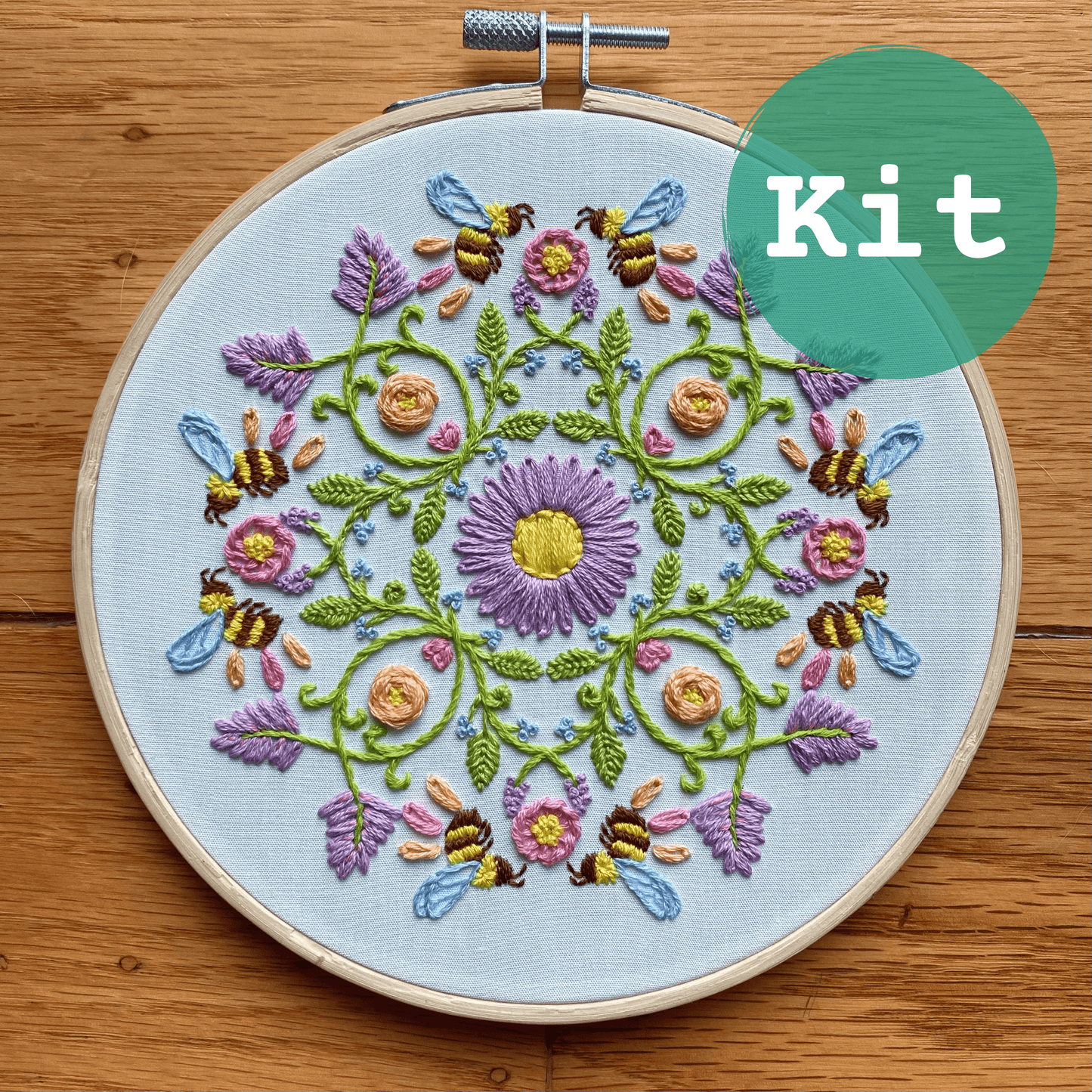 Bee mandala sampler embroidery kit with pastel florals and honeybees in a wooden hoop.