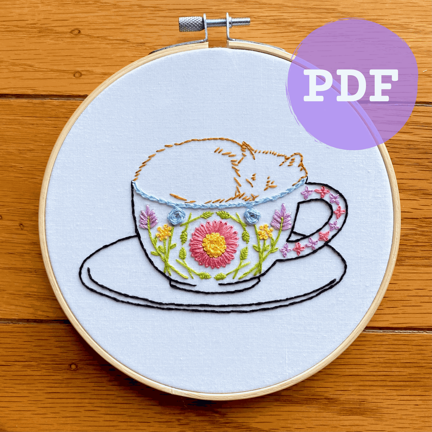 Catpuccino embroidery PDF pattern featuring a cat in a floral mug.