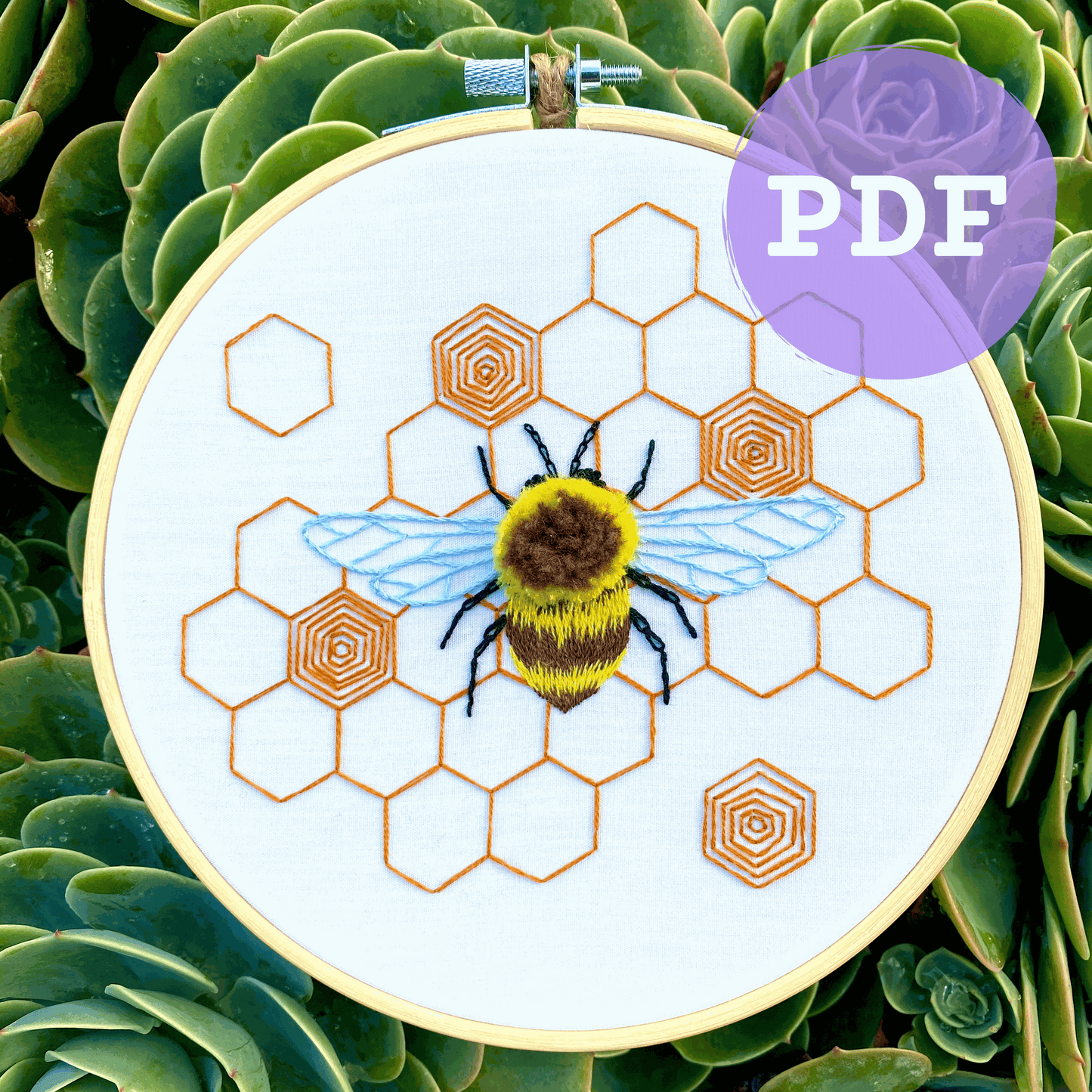 Fuzzy bumblebee embroidery on honeycomb pattern displayed in hoop, digital PDF pattern download.