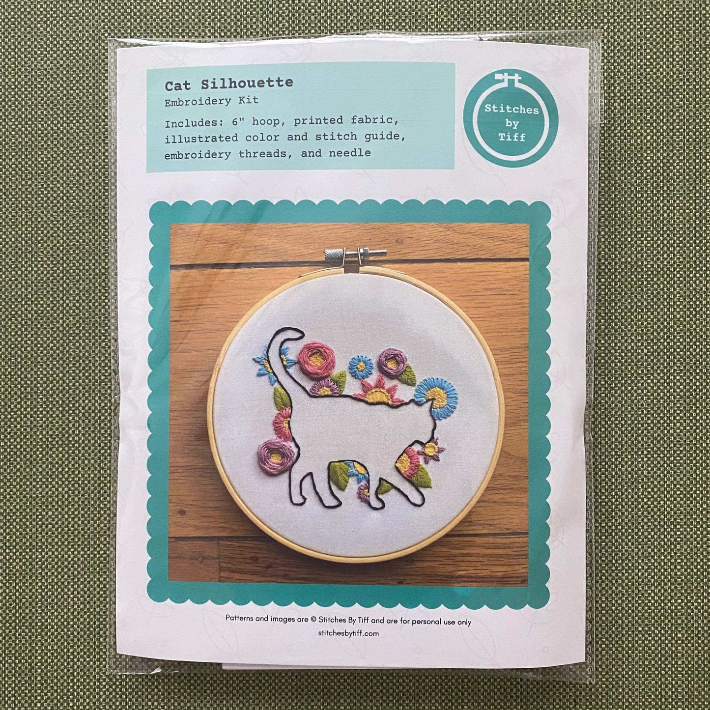Beginner cat embroidery kit with floral design, includes bamboo hoop, fabric, needle, and threads for creative stitching.