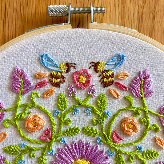 Bee mandala sampler embroidery kit with pastel florals and honeybees in a 6" hoop.