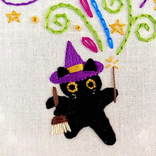 Embroidery kit with black cat design, featuring vibrant colors and sparkly thread, suitable for beginner stitchers.