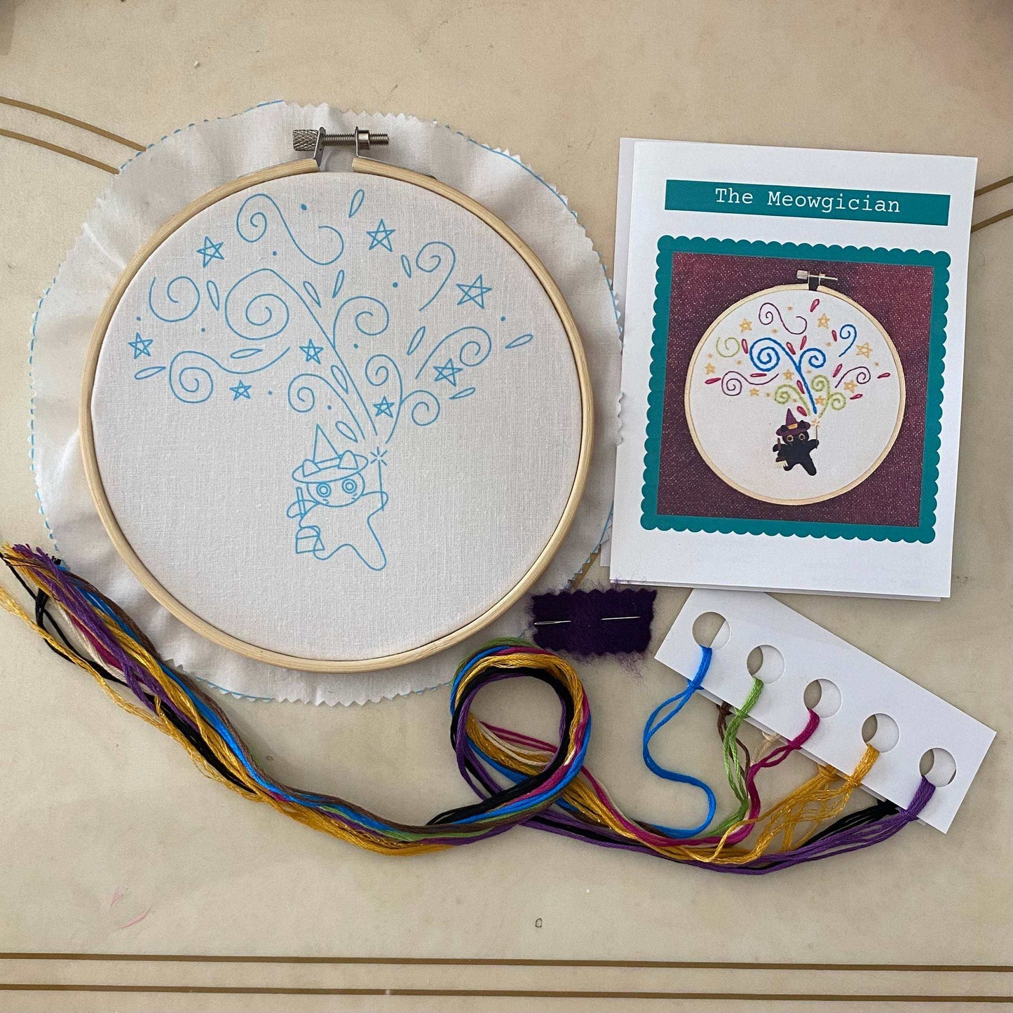 Embroidery kit featuring Percival the Meowgician, with hoop, colorful threads, needles, and instructions for cat-themed stitching fun.