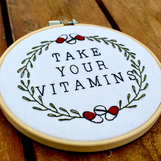 Take Your Vitamins embroidery kit with motivational quote and wreath design in bamboo hoop.