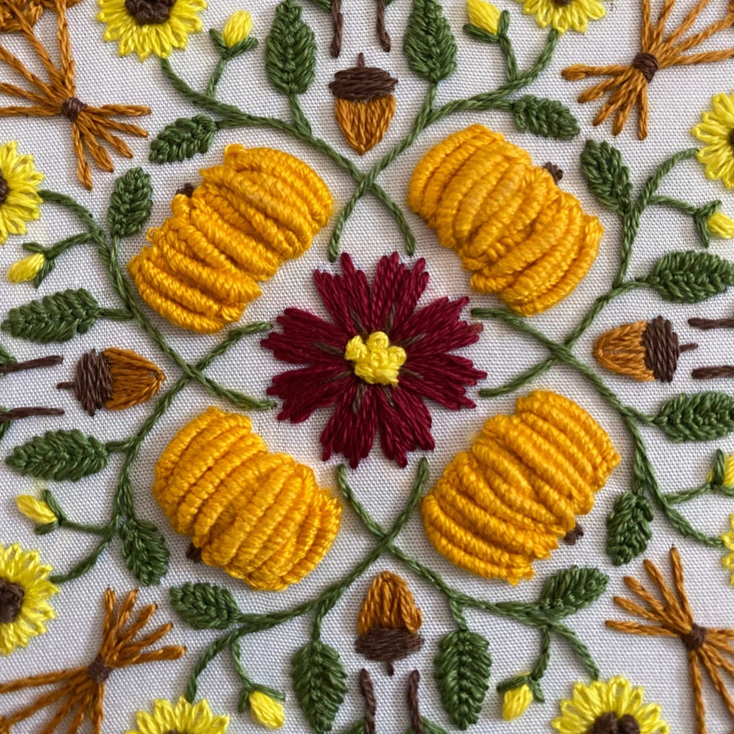 Autumn-themed mandala embroidery with pumpkins and flowers, ideal for intermediate crafters.