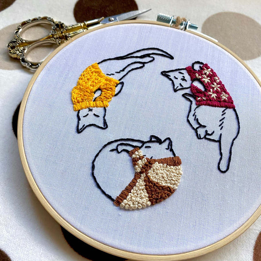Embroidery kit with cozy sweater kitties design, ideal for beginners, includes hoop, needle, and instruction guide.
