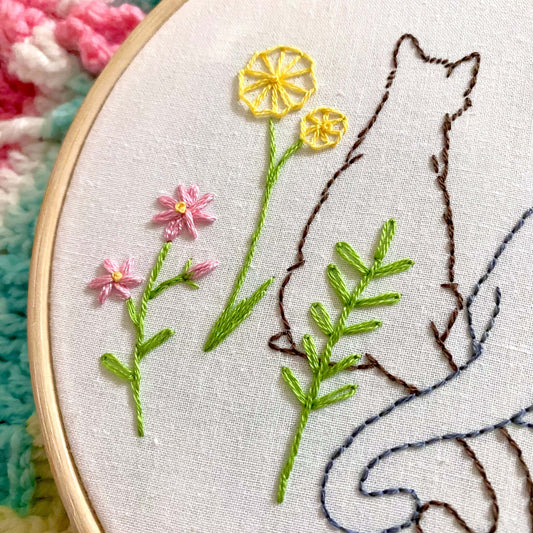 Beginner-friendly embroidery kit featuring two cats in a garden design, includes bamboo hoop, fabric, needle, guide, and threads.