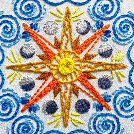 Celestial Mandala Embroidery Kit with sun, moon, stars design, bold colors, and sparkly thread.