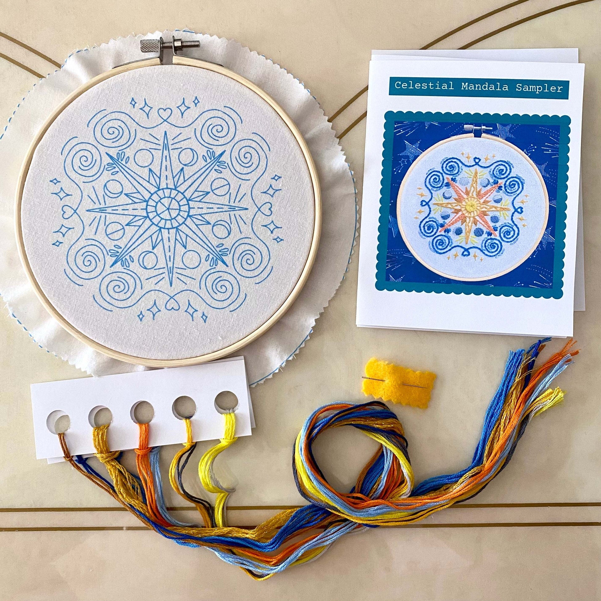Celestial Mandala Sampler Embroidery Kit with hoop, preprinted fabric, needle, instructions, and colorful threads.